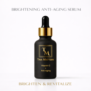 Tina Mattern Vitamin C + Anti-Aging Serum in matte black glass dropper bottle with gold accents on a white background, designed to brighten and revitalize skin